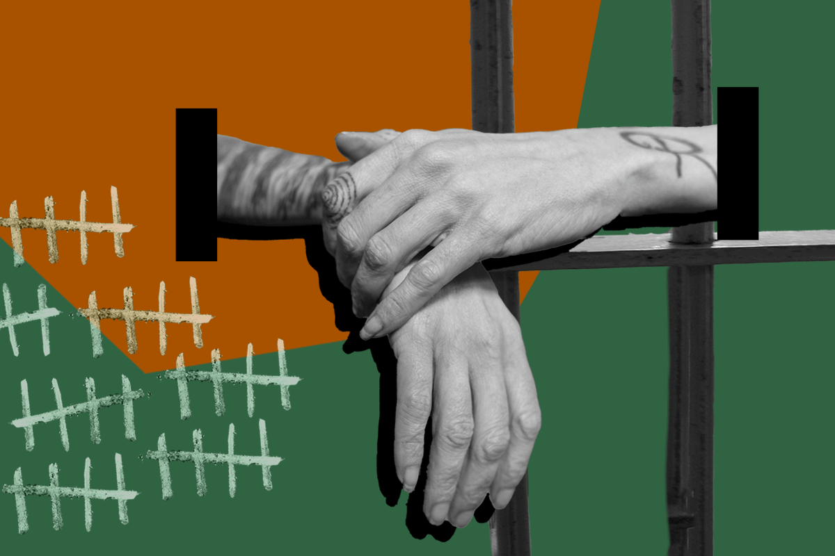 Hands folded over prison bars