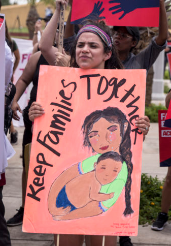 Activist with sign "Keep Families together"