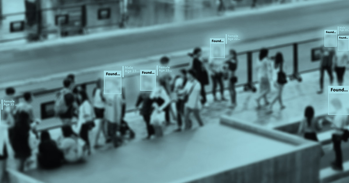 Black and light blue image of passengers walking through a train station with facial recognition simulated on top of their faces.